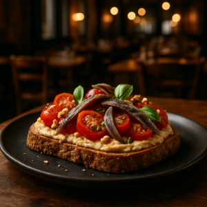 Bruschetta topped with cherry tomatoes, hummus, and anchovies.